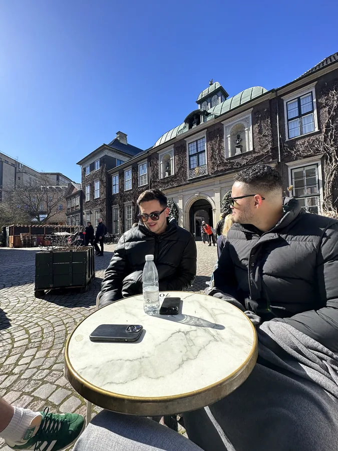 Klaudio and Derick sitting together at an outdoor café
